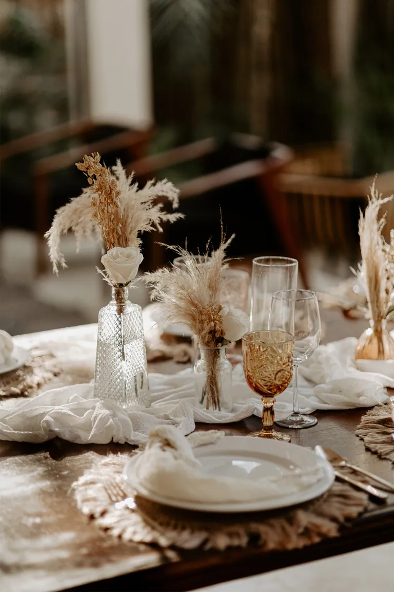 Mesa de cena de boda bajo las palmeras en Ambre Epices